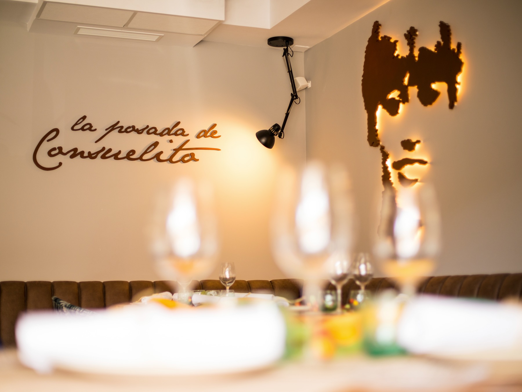 Rótulo y rostro retroiluminado en el interior de Posada Consuelito